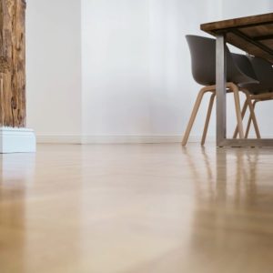 Visto a filo pavimento di un parquet lucido in una stanza con tavolo, sedie e antica colonna centrale in legno