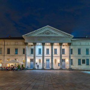 Vista notturna della facciata principale del Teatro Sociale di Como, illuminata