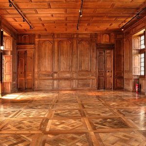 La stanza di un antico palazzo rivestita interamente in legno, dal soffitto a le pareti, con pavimento in parquet a quadrotti