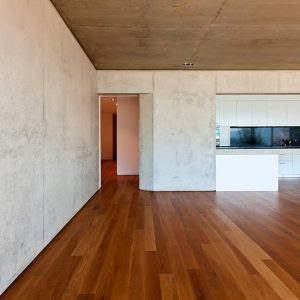 Stanza minimale e vuota con pareti e soffitto in cemento e pavimento in parquet