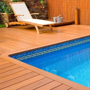 Esterno con decking a bordo piscina con sedie a sdraio