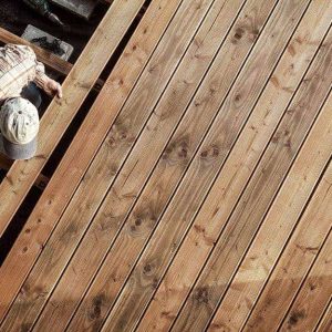 Vista dall'alto su un operaio che sta installando un pavimento in legno di Douglas su una terrazza