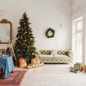 Un'elegante e luminoso salotto in stile vintage, tutto suoi toni del bianco, decorato per il Natale con addobbi non eccessivi