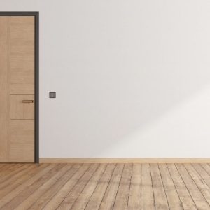 Una porta in legno alta e stretta con lo stesso colore di un parquet, in una stanza vuota con parete bianca