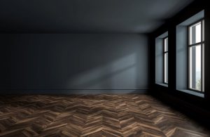 Stanza vuota sui toni del blu scuro con due finestre che illuminano un parquet a spina di pesce color cioccolato