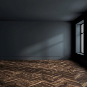 Stanza vuota sui toni del blu scuro con due finestre che illuminano un parquet a spina di pesce color cioccolato