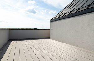 Una terrazza di una lussuosa casa minimale, con pavimento in decking in legno grigio chiaro