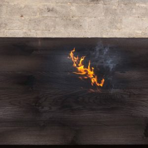 Delle fiamme sulla superficie di una tavola di legno che sta bruciando, durante il trattamento detto Yakisugi