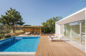 Giardino esterno di una villa di architettura modernista, con piscina e decking