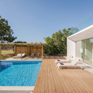 Giardino esterno di una villa di architettura modernista, con piscina e decking