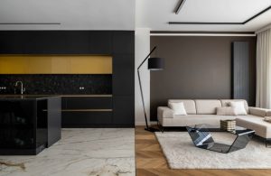 Lussuoso open space con cucina e salotto in stile contemporaneo, con il pavimento in marmo e parquet a dividere visivamente i due ambienti